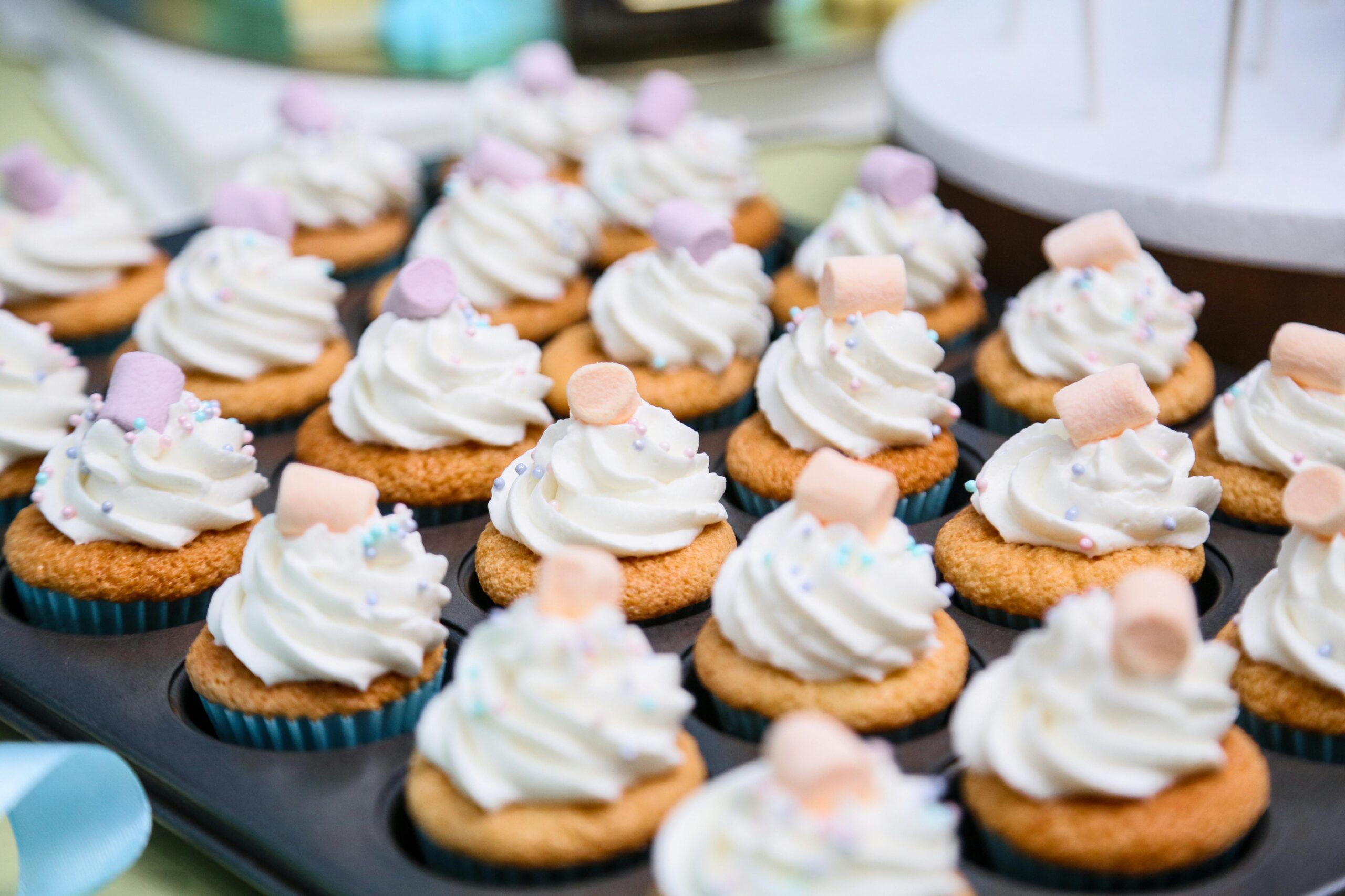 Close-up of cupcakes topped with whipped cream and marshmallows, perfect for dessert cravings.
